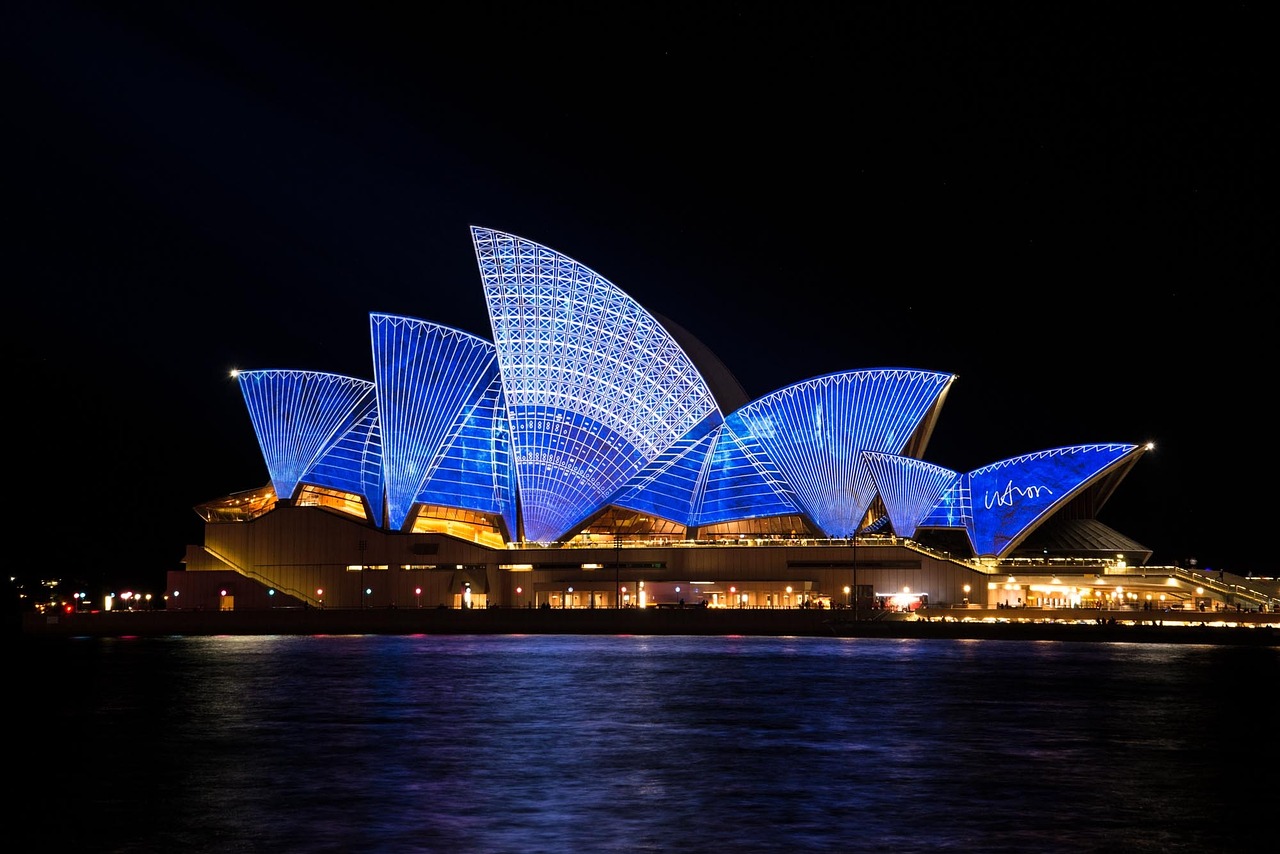 Image of the Sydney Opera House lit up under the black night sky